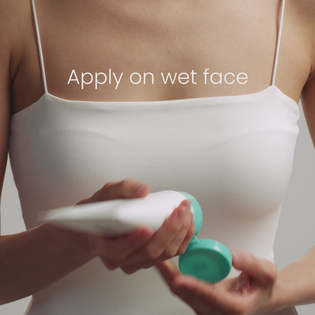 Person in a white top holding a white tube with a teal cap, text above reads "Apply on wet face."