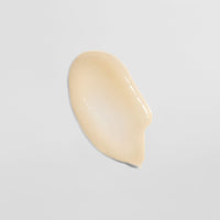 Beige Cremetropfen auf weißem Hintergrund.