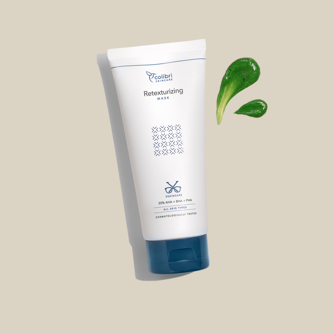 Tube einer Hautpflege-Maske mit grünem Gel auf beigem Hintergrund abgebildet.